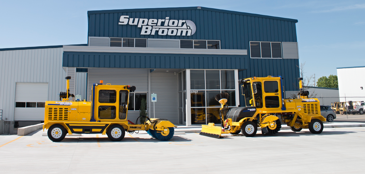 Two brooms in front of the Superior Broom building